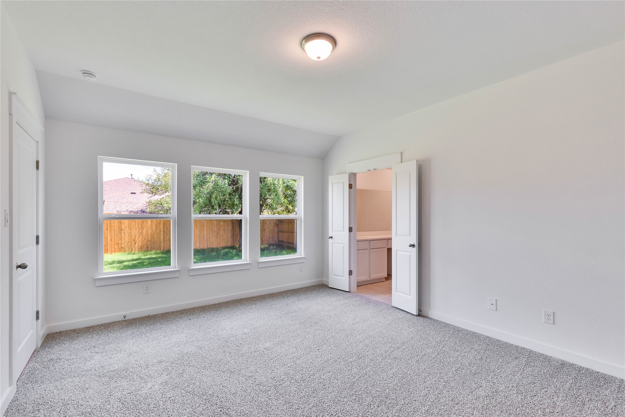 13509 Barn Chime Street Elgin, TX 78621 - Photo 10 of 30 Unfurnished bedroom with light carpet, lofted ceiling, and ensuite bath