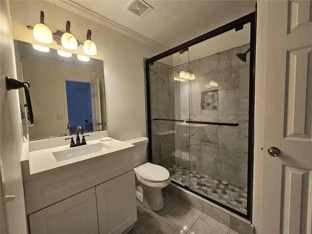 a bathroom with a sink a toilet a mirror and shower