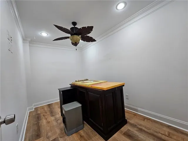 a room with wooden floor and ceiling fan