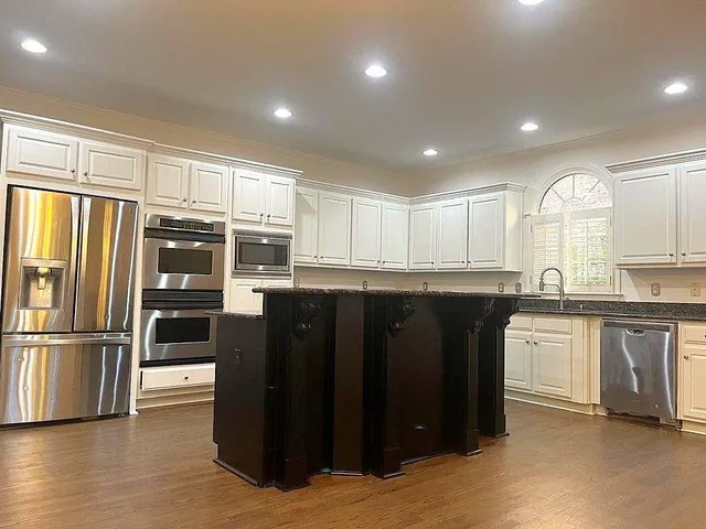 a kitchen with stainless steel appliances granite countertop a refrigerator and a sink