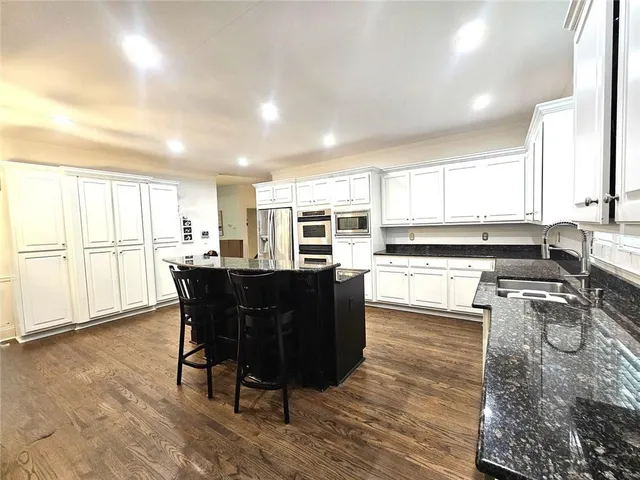 a kitchen with a table chairs refrigerator and cabinets