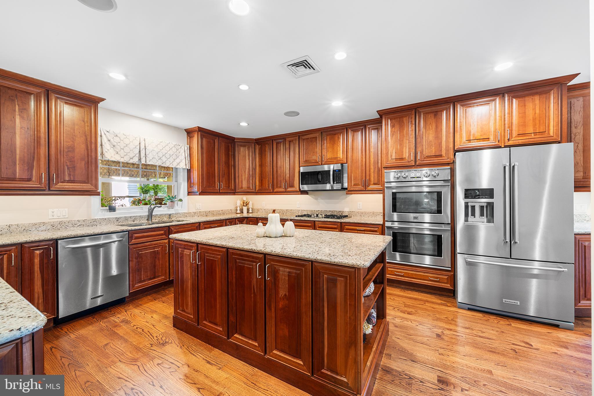 524 Sagamore Road Havertown, PA 19083 - Photo 13 of 43 a kitchen with stainless steel appliances granite countertop a refrigerator a sink dishwasher a stove and white countertops with wooden floor