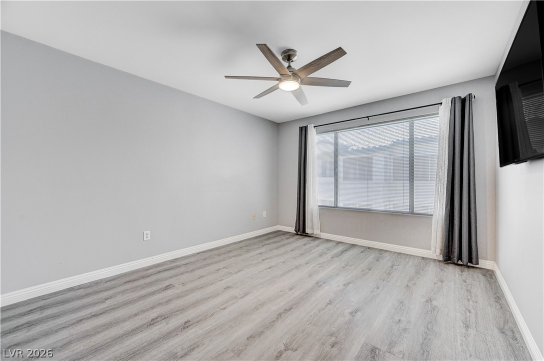 3425 East Russell Road, Unit 223 Las Vegas, NV 89120 - Photo 19 of 47 Laminate wood flooring and a contemporary ceiling fan define this comfortable bedroom space.