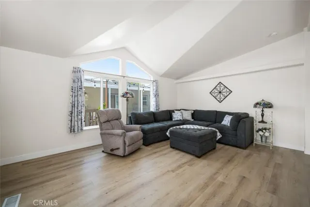 a kitchen with stainless steel appliances granite countertop white cabinets a sink a stove a refrigerator and grey cabinets