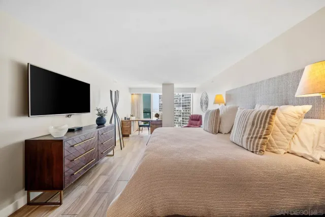 a bedroom with a bed and flat screen tv