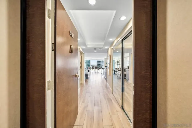 a view of a hallway with wooden floor staircase and a bathroom
