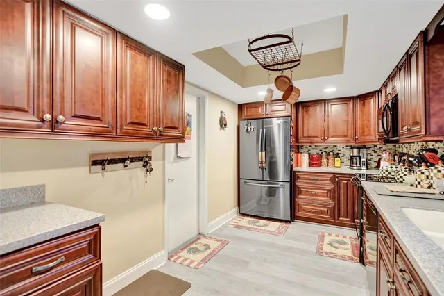 a kitchen with stainless steel appliances granite countertop a refrigerator and a sink