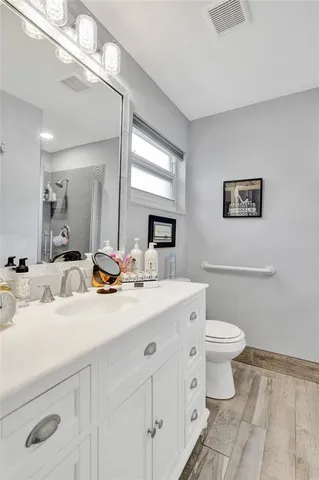 a bathroom with a toilet a sink and mirror