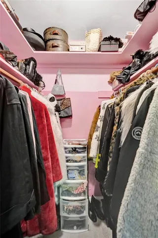 a view of walk in closet with clothes and shoes