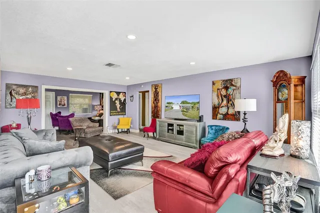a living room with furniture a flat screen tv and a window