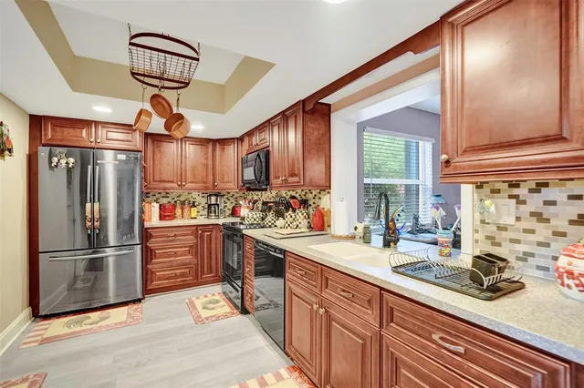 a kitchen with granite countertop a sink stainless steel appliances and cabinets