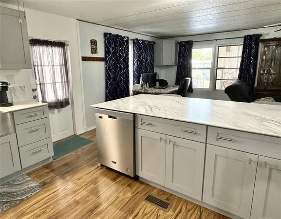 a kitchen with white cabinets and window