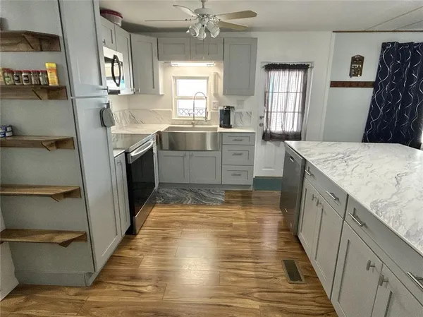 a kitchen with granite countertop a sink stove and cabinets
