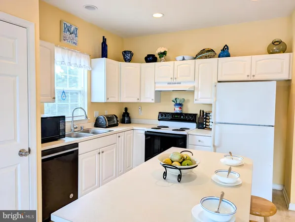 a kitchen with stainless steel appliances a white table and chairs in it