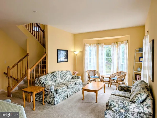 a living room with furniture and a large window with wooden floor