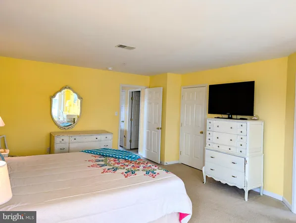 a bedroom with a bed a flat screen tv and cabinets