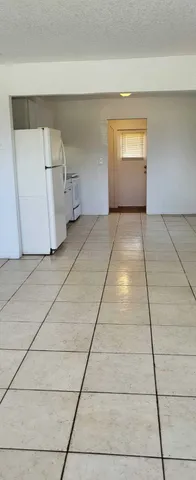 a kitchen with granite countertop a sink a stove and cabinets