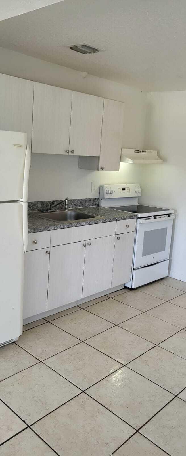 4998 Kirk Road Lake Worth, FL 33461 - Photo 21 of 22 a kitchen with granite countertop a sink a stove and cabinets