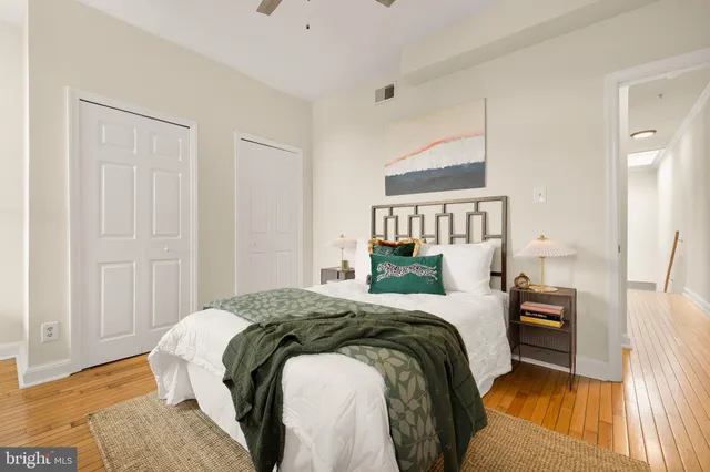 a bedroom with a bed and a lamp on the dresser