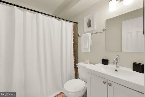 a bathroom with a sink a toilet and shower curtain