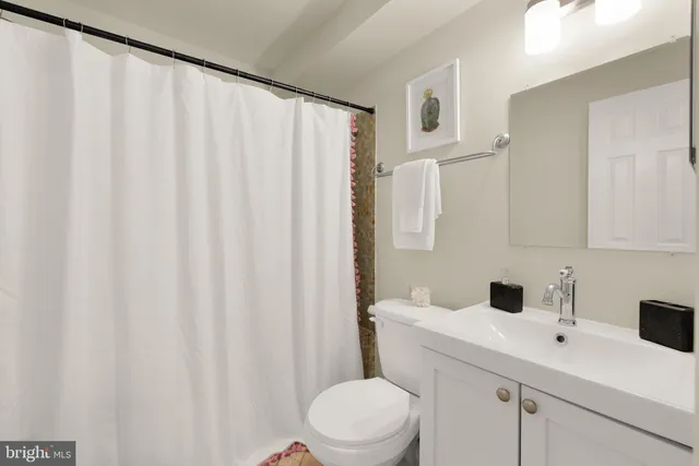 a bathroom with a sink a toilet and shower curtain