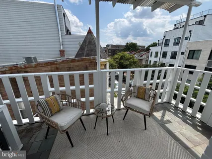 a view of a chairs and table on the roof deck