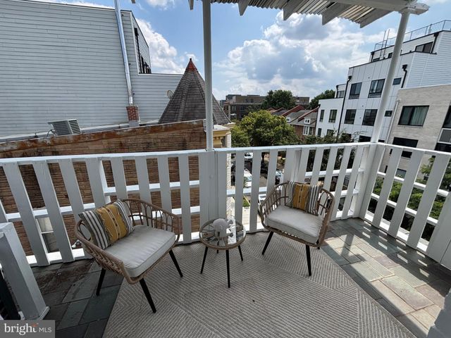 a view of a chairs and table on the roof deck