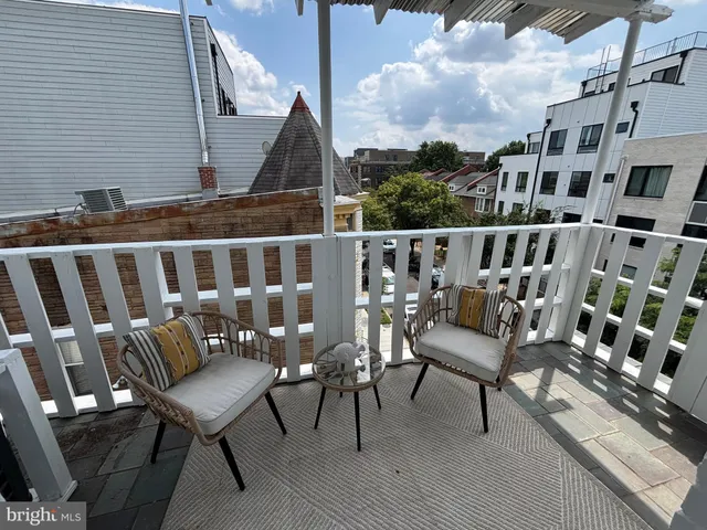 a view of a chairs and table on the roof deck