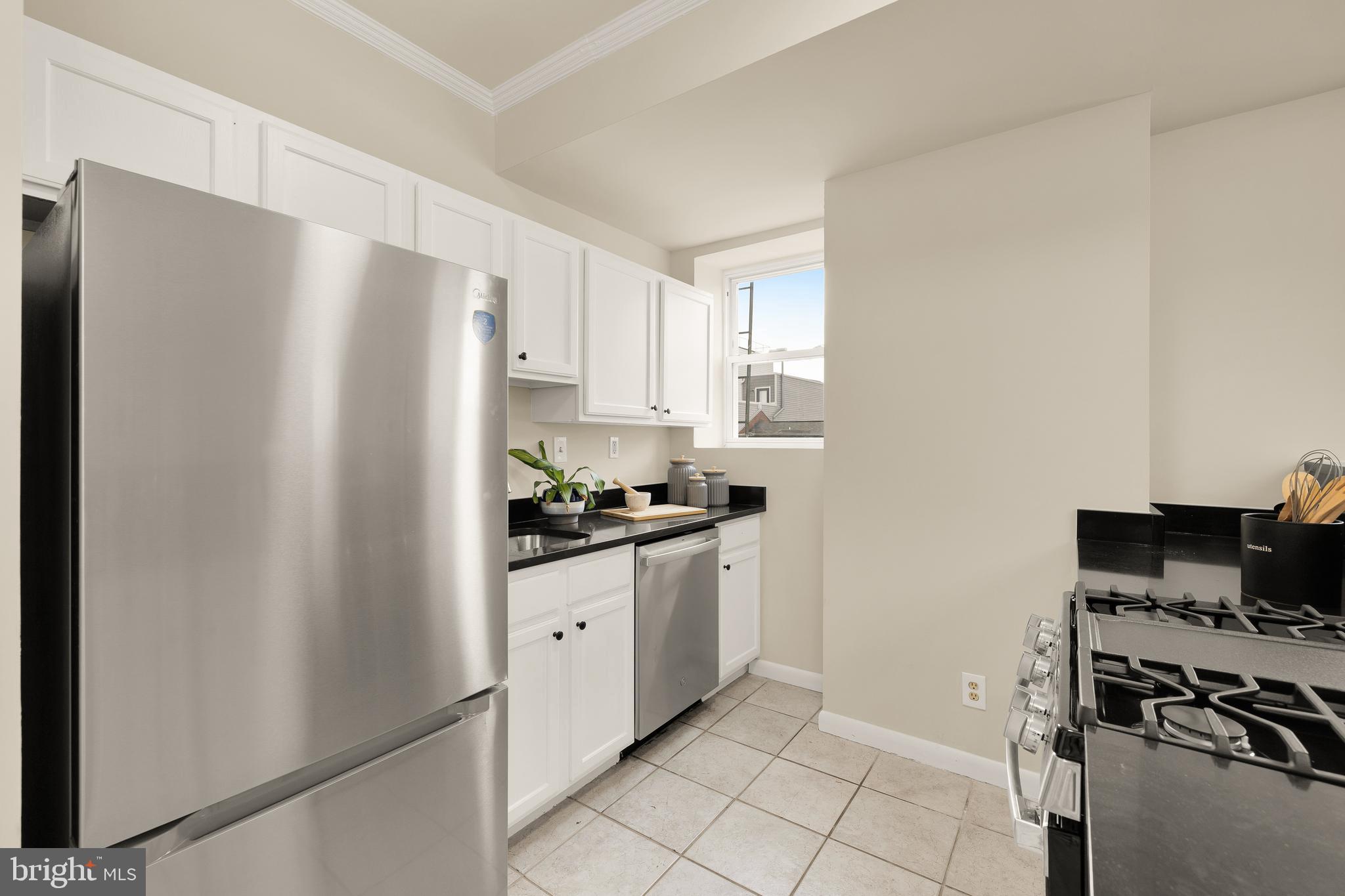 1458 Fairmont Street Northwest, Unit 4 Washington, DC 20009 - Photo 10 of 24 a kitchen with stainless steel appliances a refrigerator sink and stove
