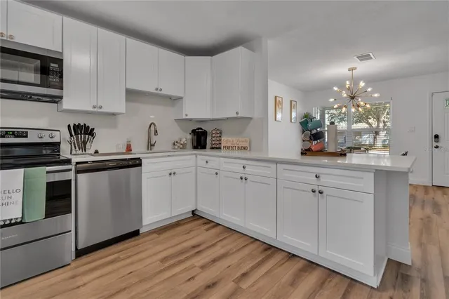 a kitchen with cabinets a sink and stainless steel appliances
