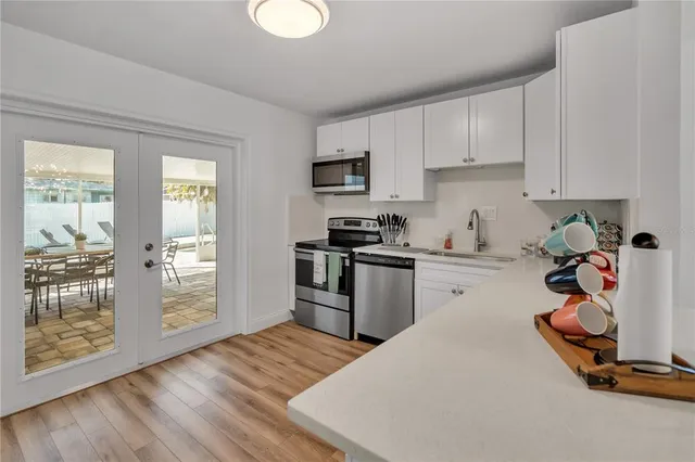 a kitchen with a refrigerator a stove top oven a sink and cabinets