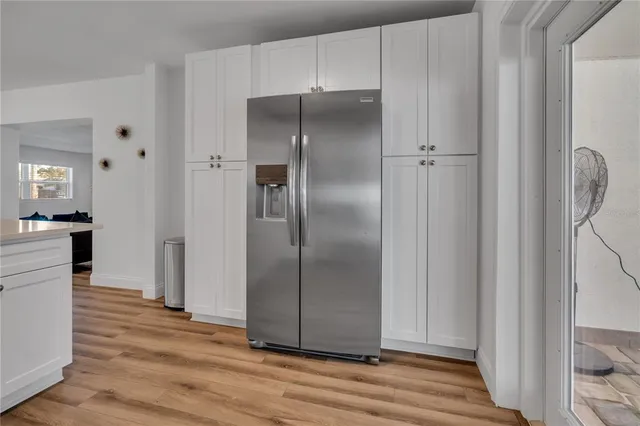 a view of a refrigerator in kitchen and wooden floor