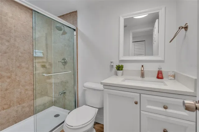 a bathroom with a sink toilet vanity and shower
