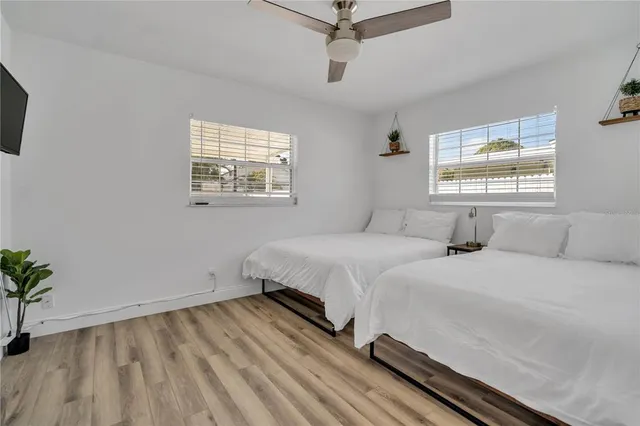 a spacious bedroom with two beds and a potted plant