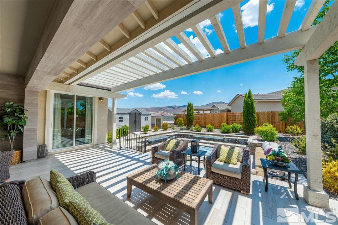 9920 Hafflinger Lane Reno, NV 89521 - Photo 29 of 36 a view of a patio with dining table and chairs with wooden floor and fence