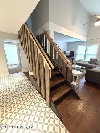 a view of staircase with lots of frames on wall and a rug