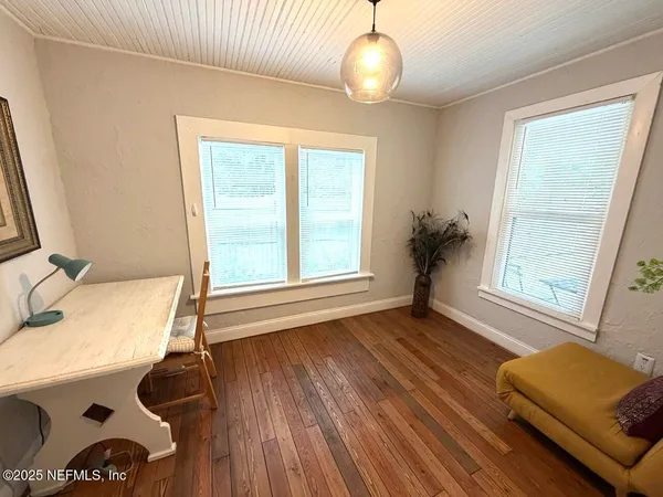 a view of a room with wooden floor and windows
