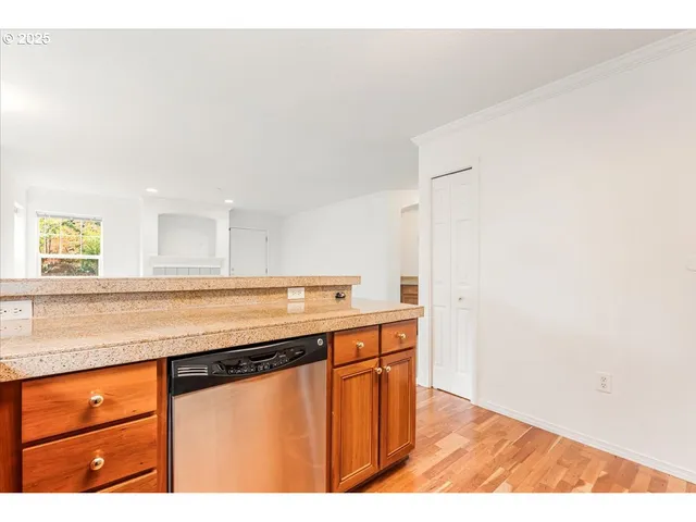a kitchen with stainless steel appliances granite countertop a sink and a wooden floor