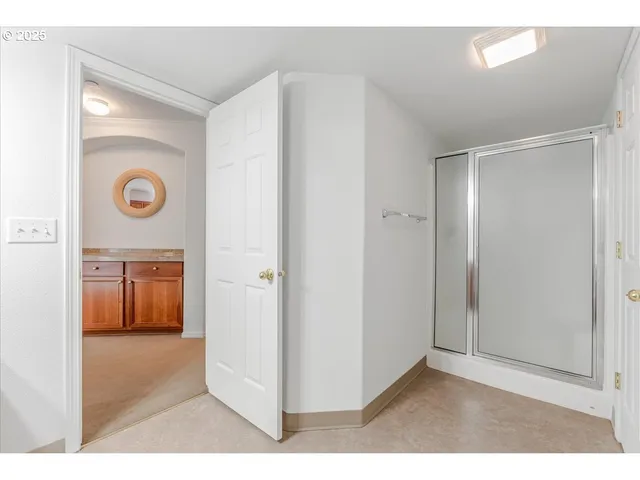 a view of a hallway with a white cabinet and a refrigerator