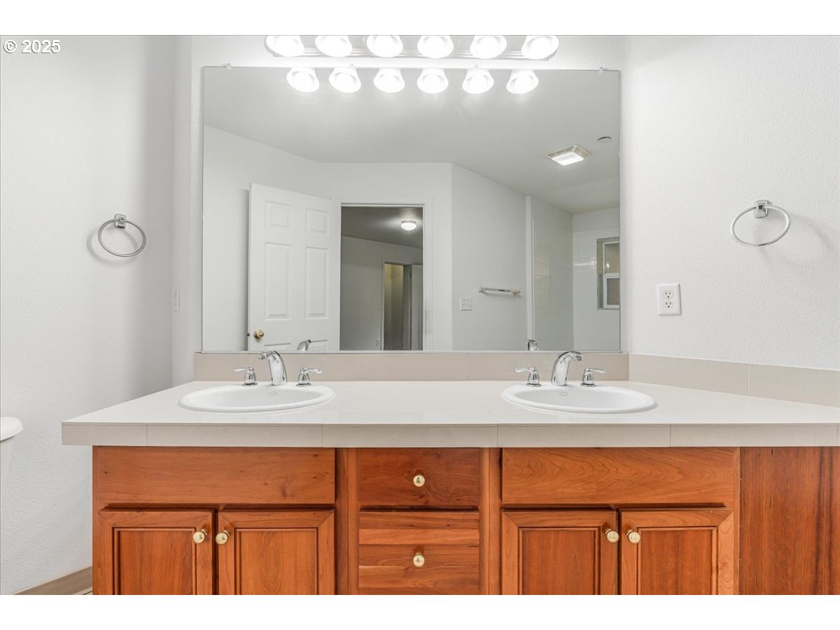 30424 Southwest Ruth Street, Unit 84 Wilsonville, OR 97070 - Photo 22 of 48 a bathroom with a sink vanity and a mirror