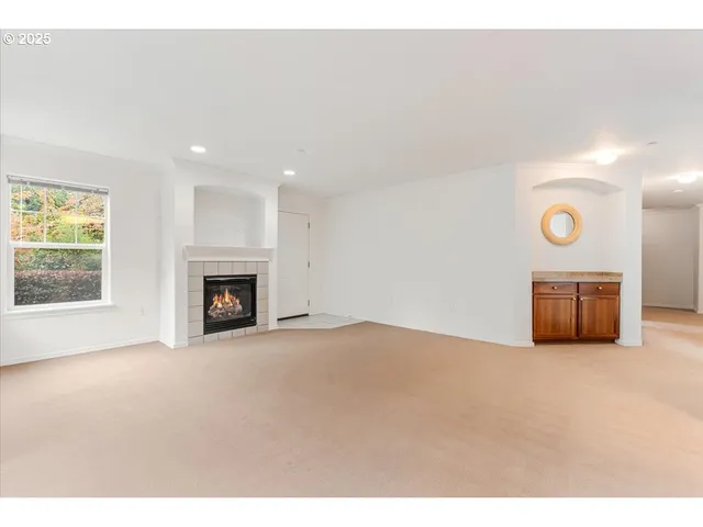 a view of an empty room with a fireplace and a window