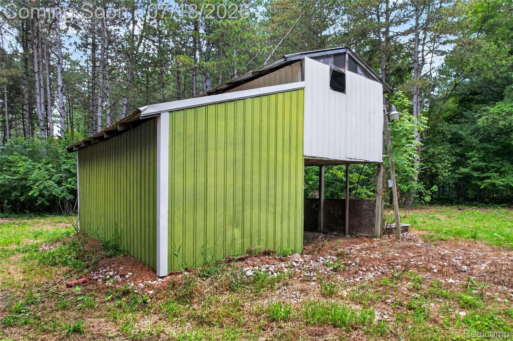 1437 East Cook Road Grand Blanc, MI 48439 - Photo 20 of 69 Outbuilding with green corrugated metal siding and a white upper section, featuring a small window and an elevated structure