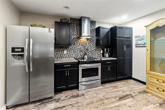 a view of a kitchen with wooden floor and cabinets