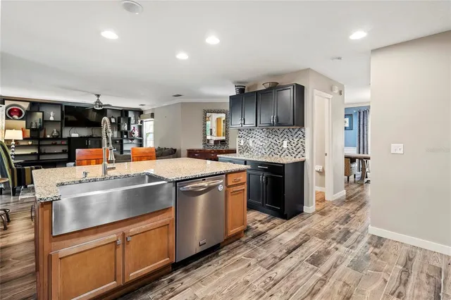 a kitchen with kitchen island granite countertop wooden cabinets and stainless steel appliances