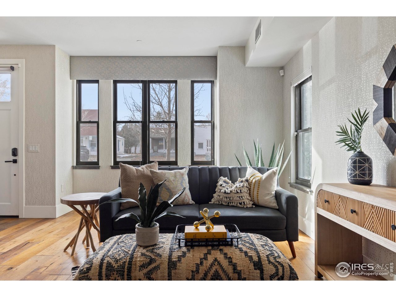 a living room with furniture and floor to ceiling windows