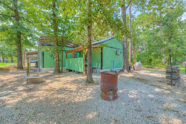 a view of a house with large trees and plants