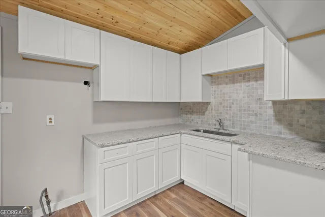 a white kitchen with sink and cabinets