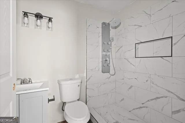 a white toilet sitting next to a bathroom sink