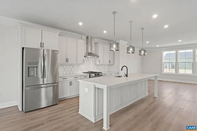 a kitchen with kitchen island white cabinets and stainless steel appliances