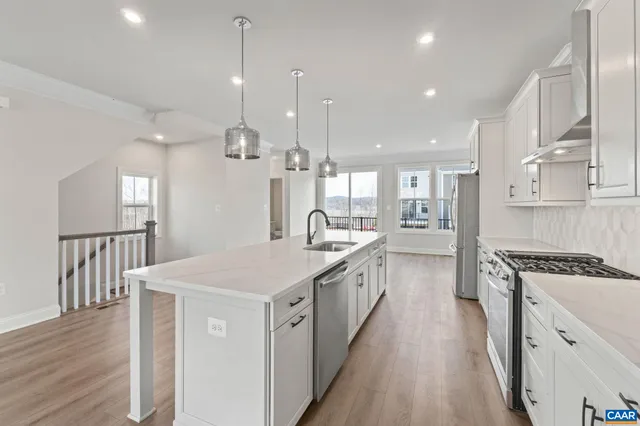 a kitchen with kitchen island a sink stove and wooden floor